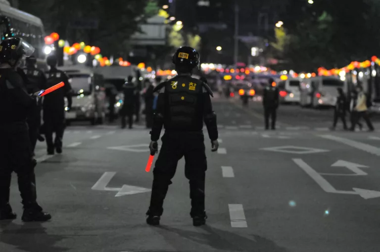 police standing on gray asphalt during nighttime