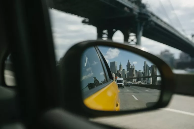 reflection in side mirror of car driving on bridge