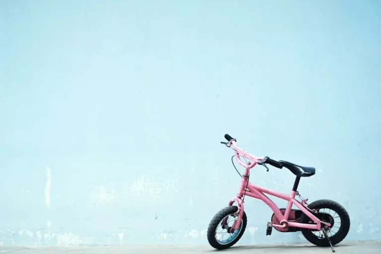 toddler s pink bike near wall