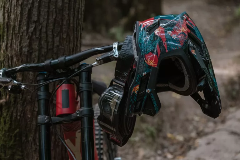 a bicycle with helmet by the tree trunk