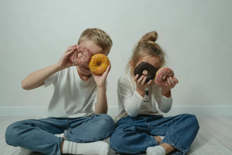 girl and boy fooling around with doughnuts