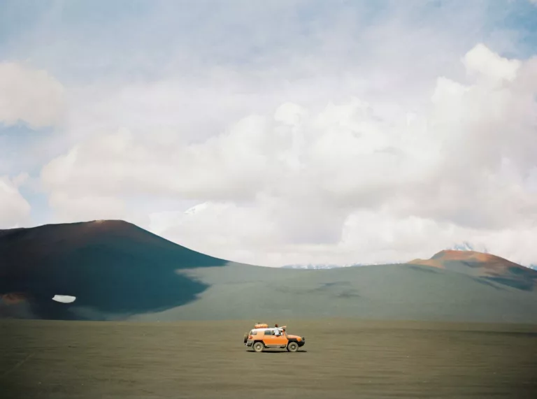 orange vehicle on brown sand