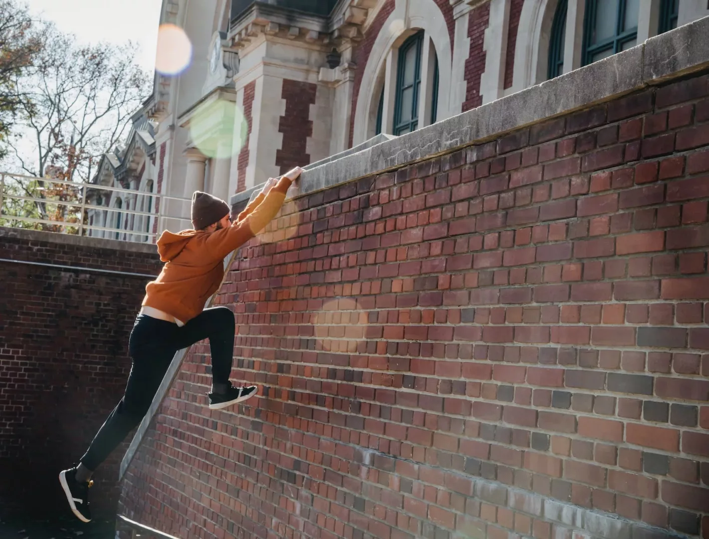 active man jumping on brick wall