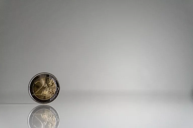 a coin on a white surface with a reflection