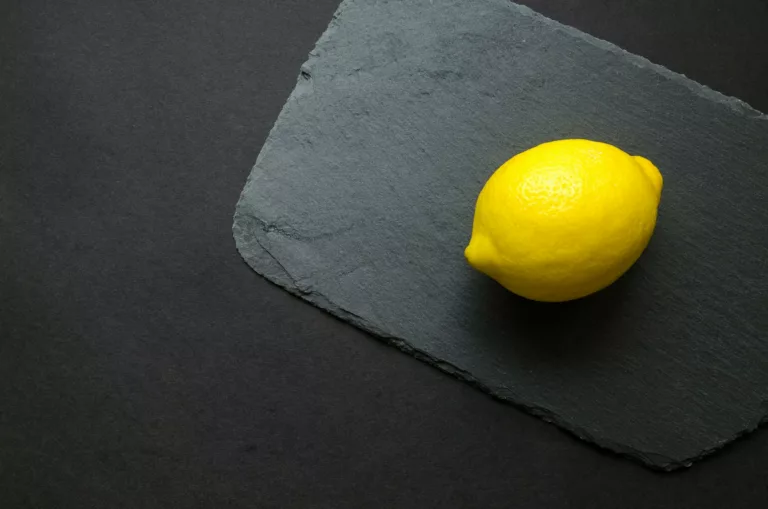 photo of yellow lemon on gray surface