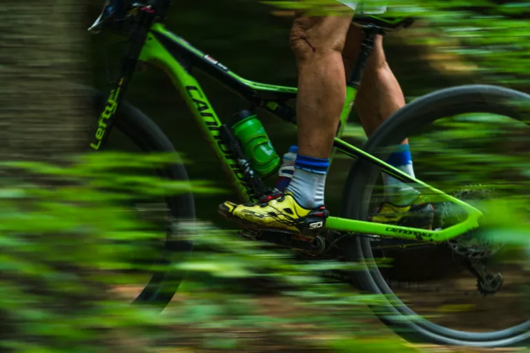man riding a green mountain bike