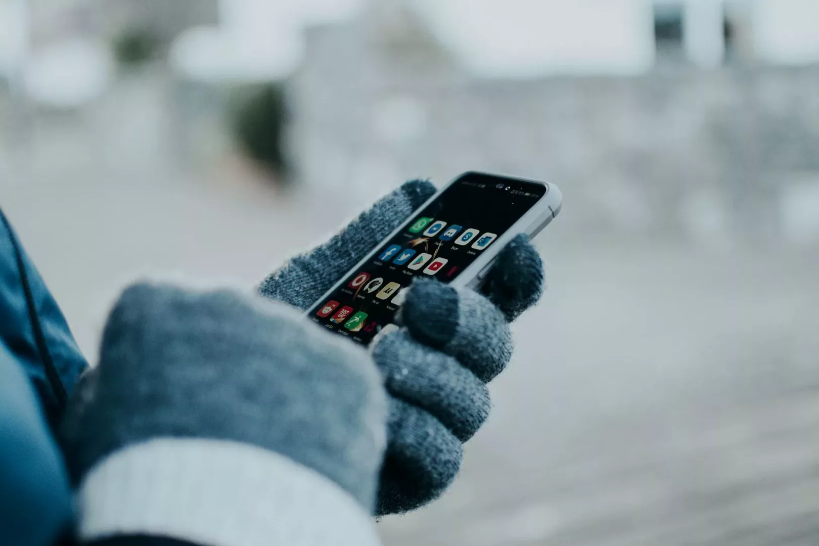 person wearing gloves holding a cellphone