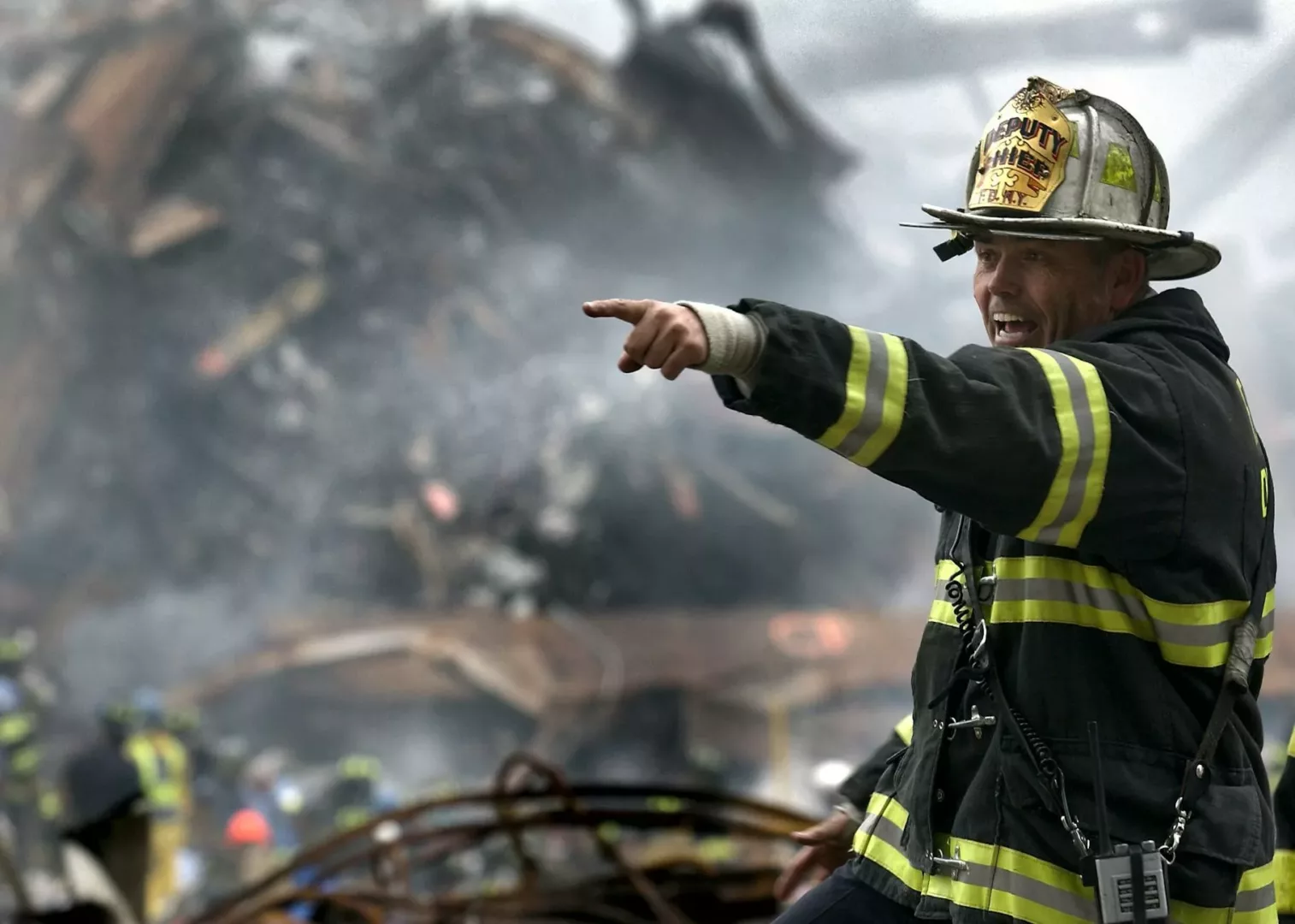 fire fighter wearing black and yellow uniform pointing for something