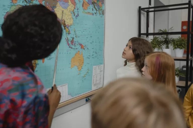 teacher teaching students about geography using a map