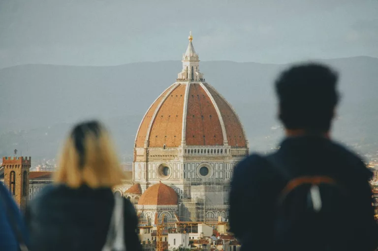 back view of people standing and looking at the santa maria del fiore cathedral in florence italy