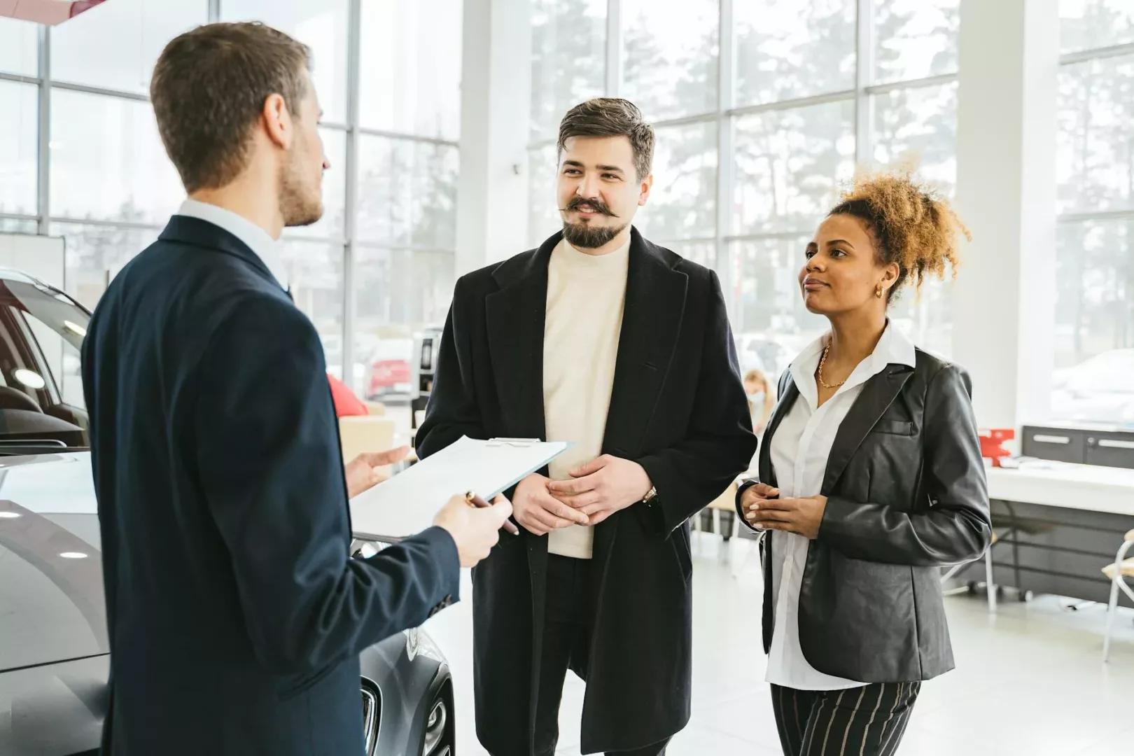 a couple talking to a car dealer