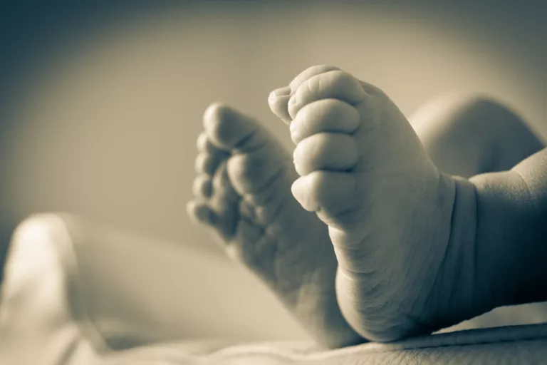baby s feet in gray scale photography