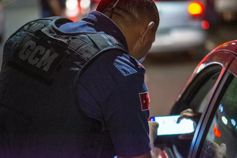 A GCM officer checks documents during night traffic control in Londrina, Brazil.