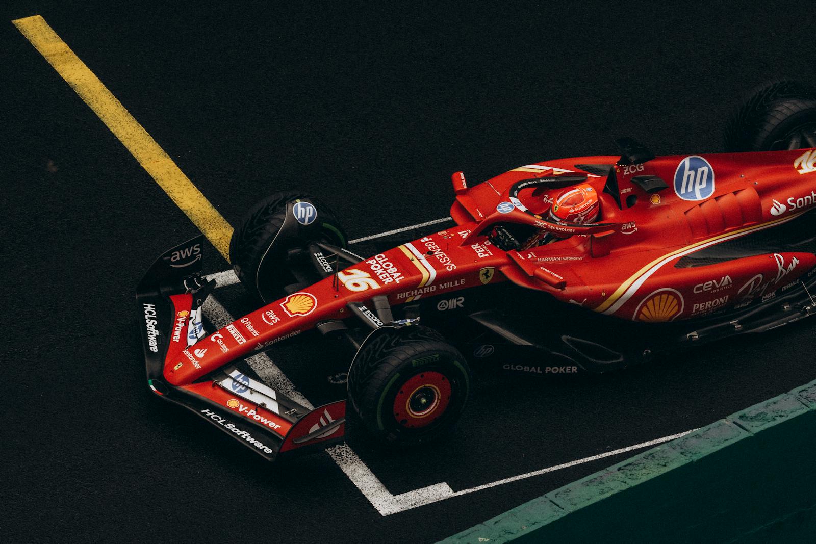 Dynamic shot of a red Formula One car racing on a track, showcasing speed and precision.