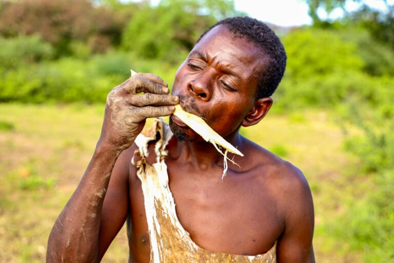 A man enjoying natural food in an outdoor setting, showcasing raw lifestyle.