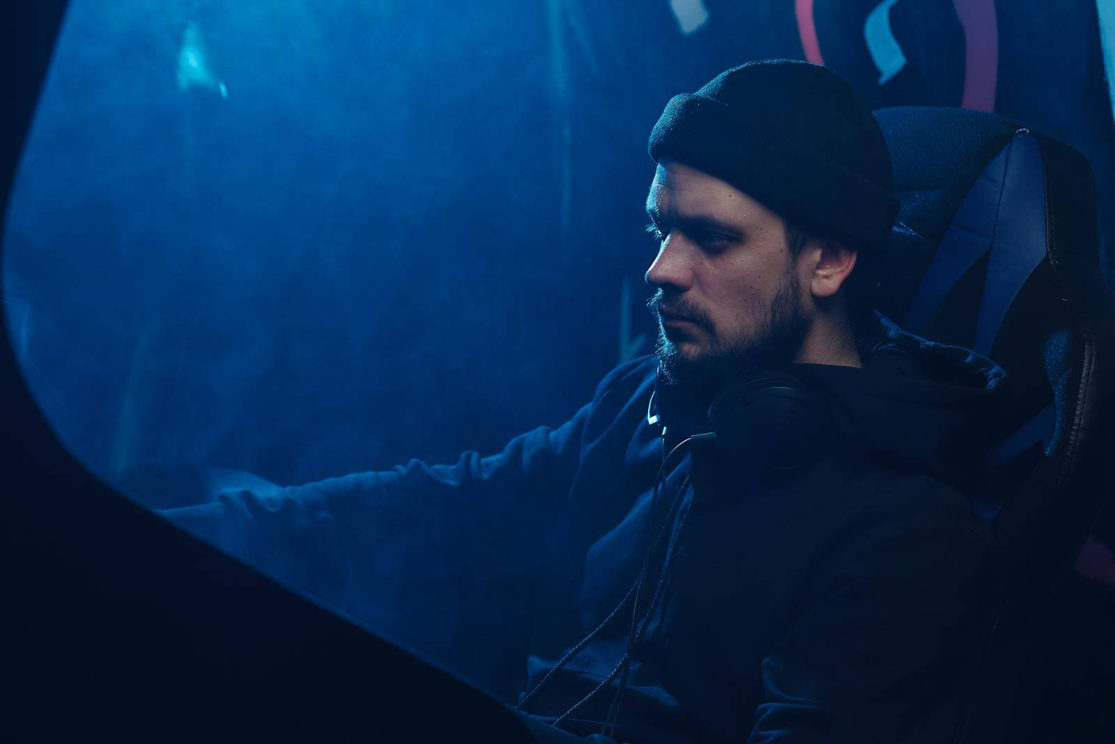 A contemplative scene featuring a man with headphones immersed in a moody blue ambiance.