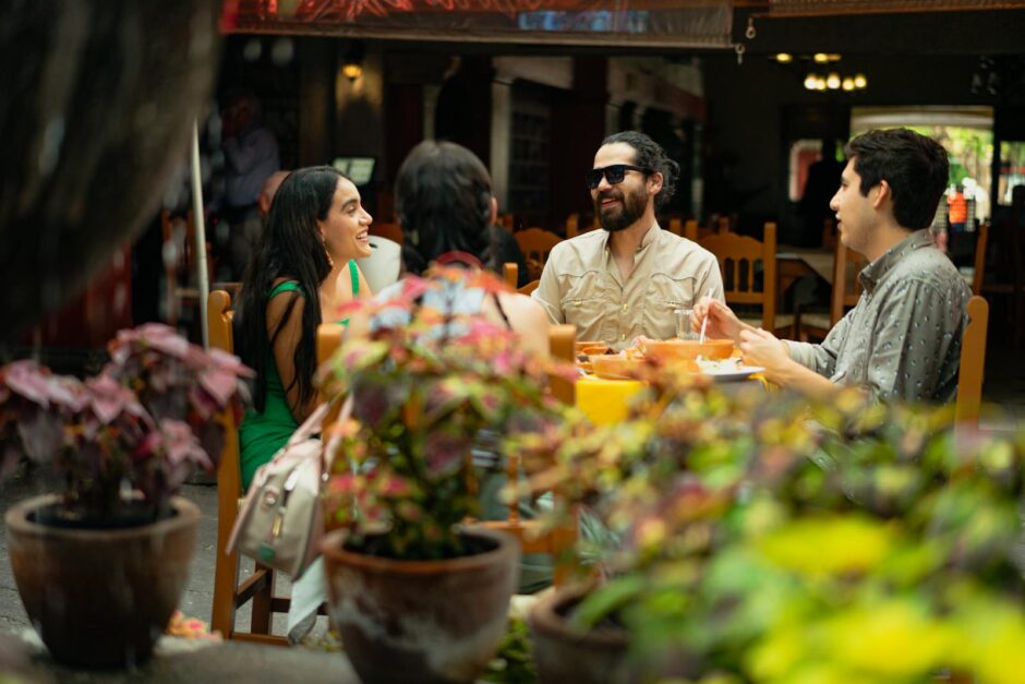 Friends enjoying a meal and conversation in a lively Mexican restaurant setting.