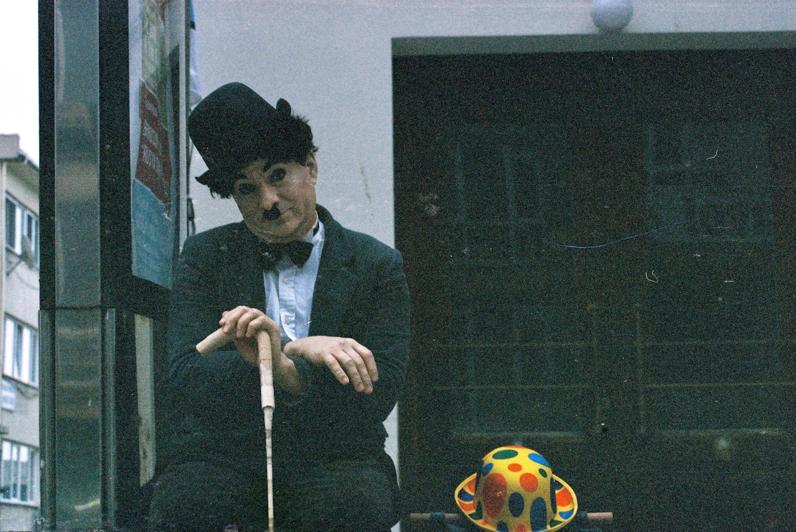 A street performer dressed as Charlie Chaplin poses outdoors in Istanbul.