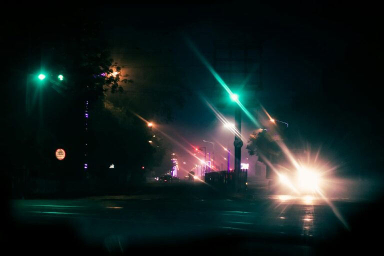 Atmospheric city street at night with bokeh lights and moody ambiance.