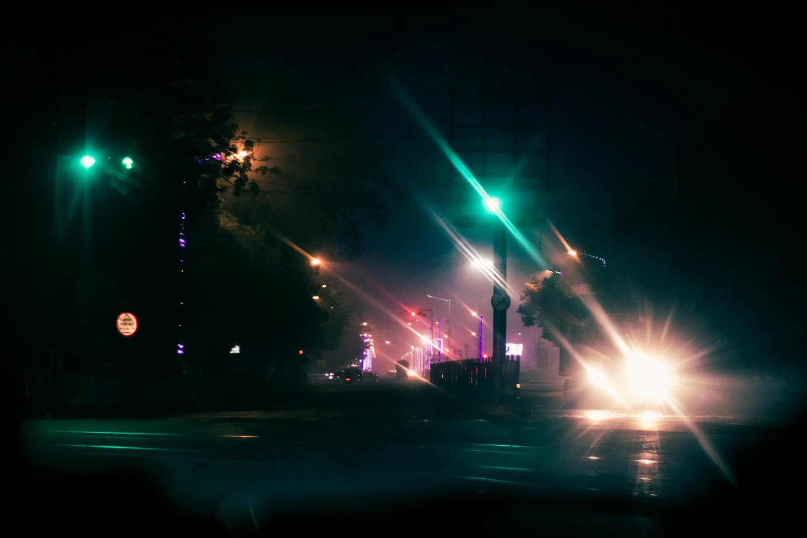 Atmospheric city street at night with bokeh lights and moody ambiance.