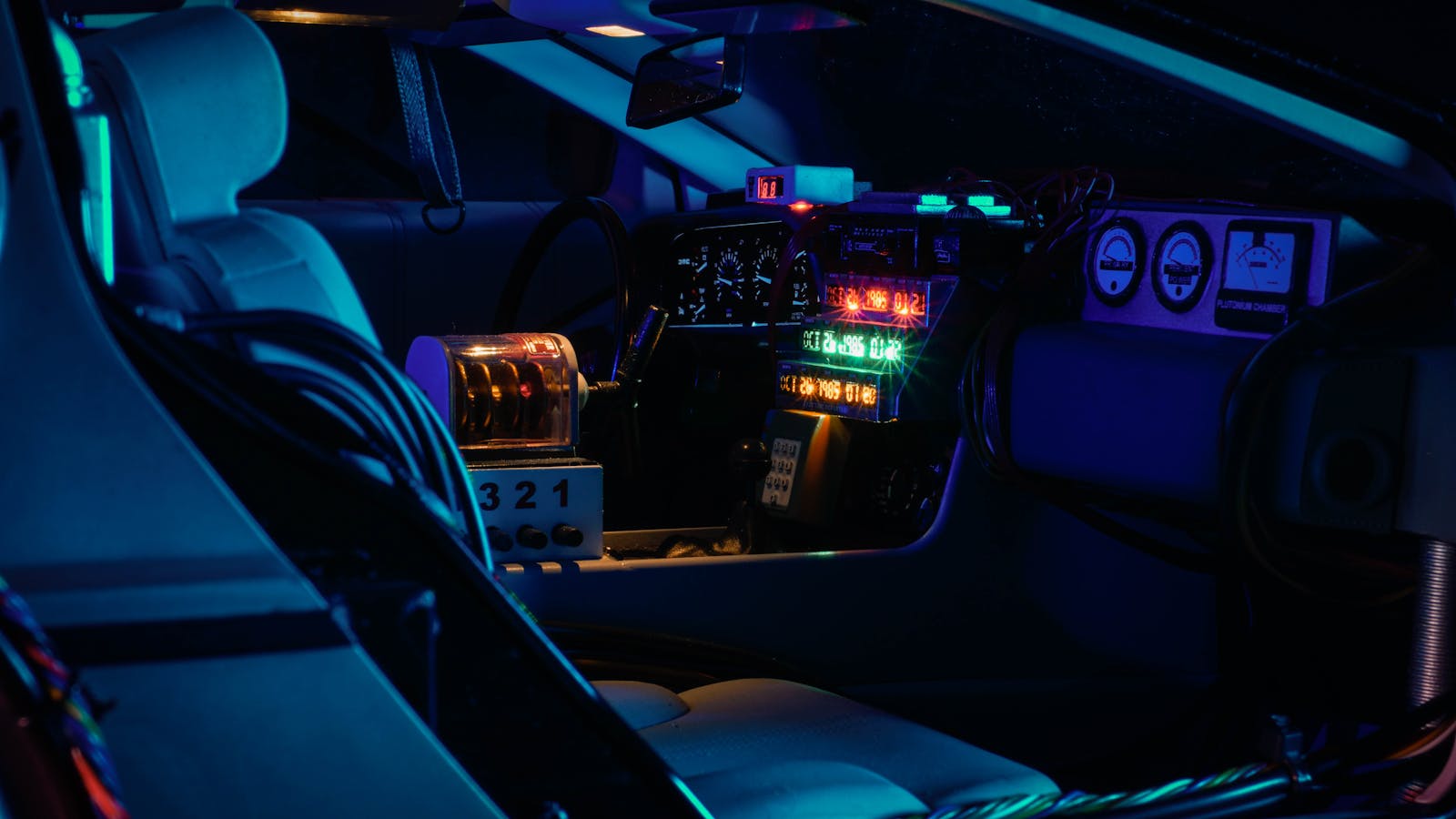 A dark futuristic car cockpit with glowing neon lights and digital displays.